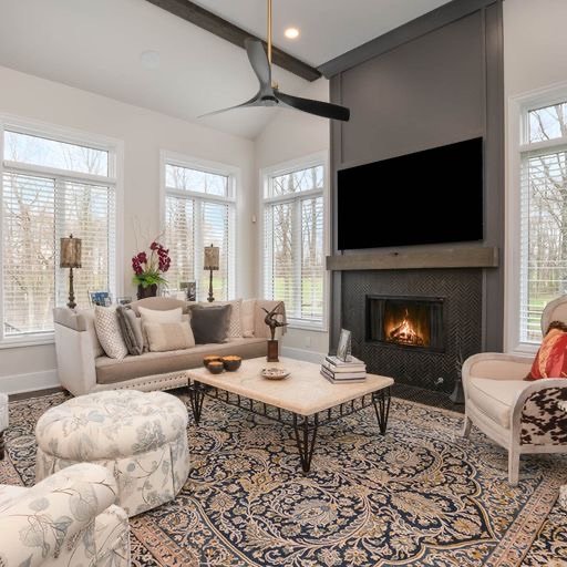 Elegant living room interior with a cozy fireplace, plush seating, and a classic ornate rug.